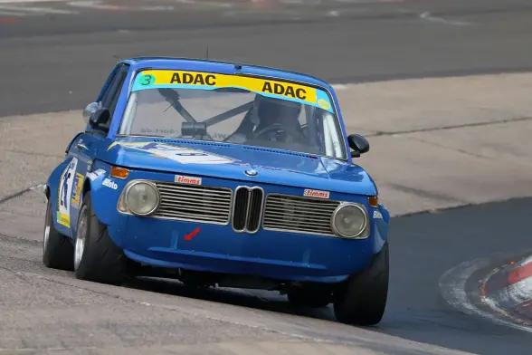 Ein BMW 2002i in blau in der Schwalbenschwanz Kurve.