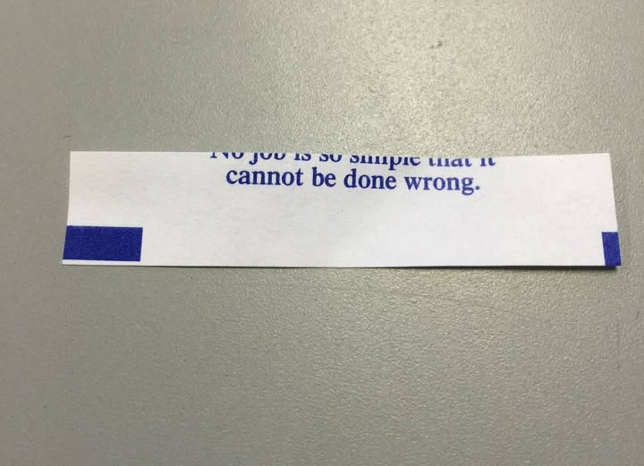 fortune cookie message which is poorly cut with the top half of the first line missing. (Reconstructed), reads "No job is so simple that is cannot be done wrong."