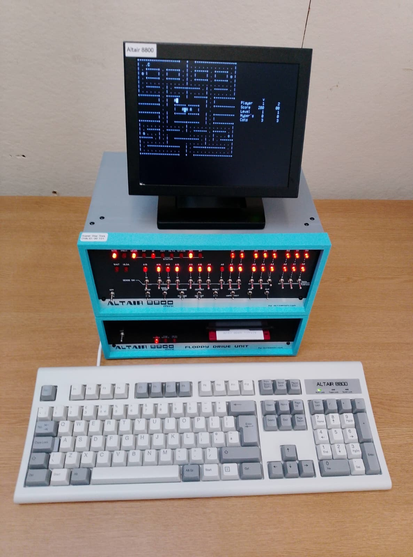 Photo of my Altair computer with its new full-size keyboard. It looks like the classic Model M IBM doobry. The little monitor on top of the computer is displaying a terminal based Pac Man game!!! I know right!