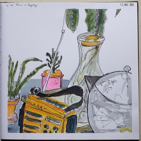 Aquarelliere Tintenzeichnung, in dem Ausschnitt eines Stilllebens gibt es ein kleines orangenes Kofferradio, eine metallene Teekanne, zwei kleine Topfpflanzen und ein bewurzelter Avocadokern in einer Glaskaraffe. Letztere steht auf einem Holztablett zusammen mit allem anderen auf eine Tisch mit grauer Tischecke.