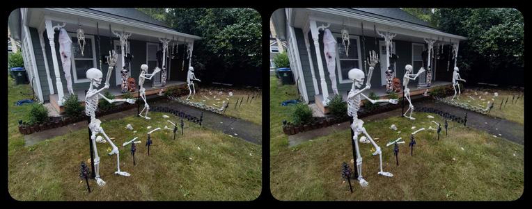 Dancing skeletons in front of a suburban house. Stereoscopic.