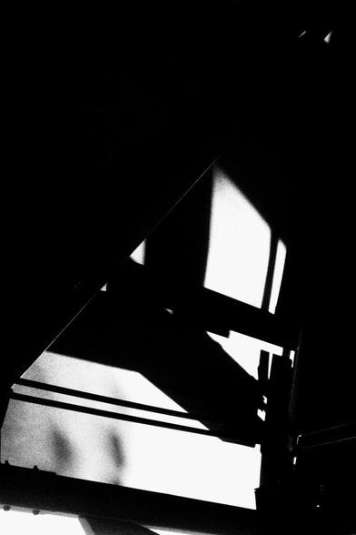 Looking upward through gaps in a backyard deck roof.