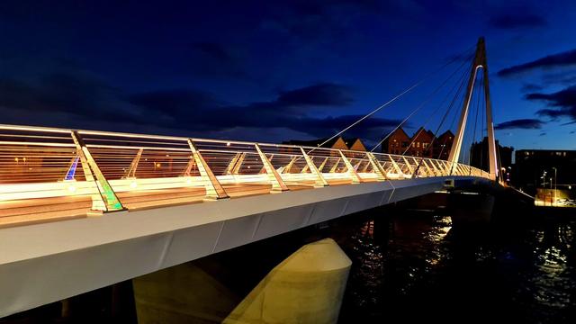 A suspension bridge lit up at night.