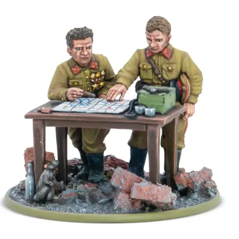 A detailed miniature scene features two Soviet officers, one with a map and the other pointing at it, engaged in strategic planning. They are dressed in military uniforms with insignia, standing beside a table cluttered with a map, a green box, and other items. The base is set on a rubble-strewn ground, with a small animal visible in the foreground, enhancing the war-torn atmosphere.