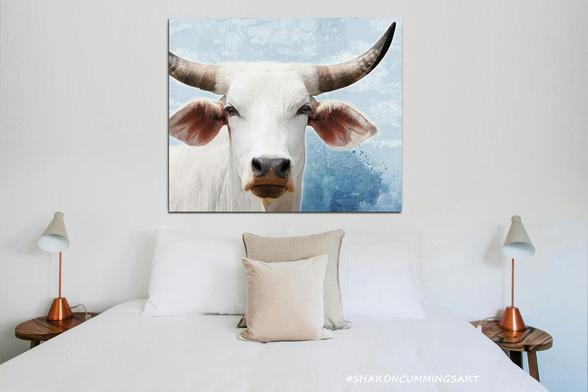 Soft white cow with horns on soft blue in a bedroom setting by artist Sharon Cummings.