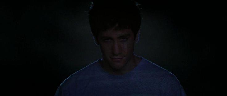 A teenage boy wearing pajamas smiles as he sleepwalks
