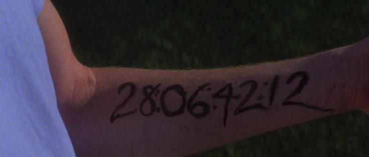 Numbers (28064212) written in black ink on someone’s inner forearm