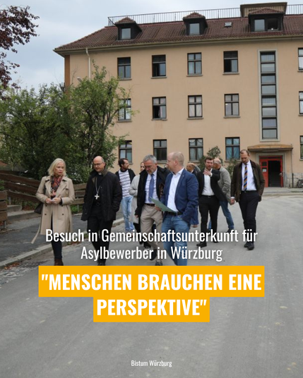 Besuch einer Gruppe bei einer Gemeinschaftsunterkunft für Asylbewerber in Würzburg, Text 'Menschen brauchen eine Perspektive' auf gelbem Hintergrund, Gebäude im Hintergrund.