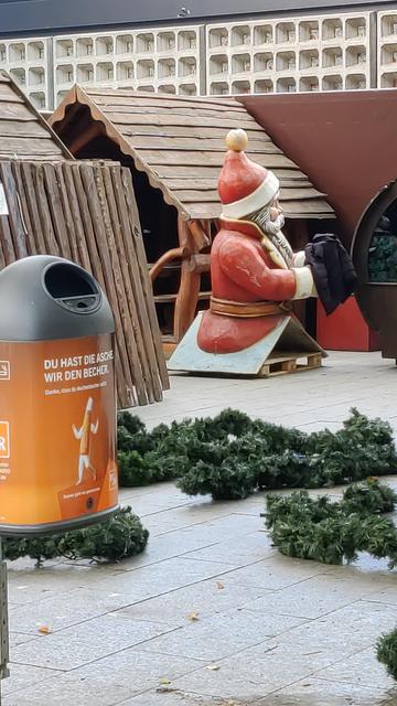 Zerlegte Teile von Buden für den Weihnachtsmarkt liegen in einer Ecke, obendrauf der Weihnachtsmann.