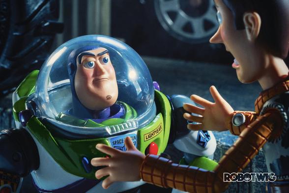 Woody shouts at Buzz under a car in a gas station