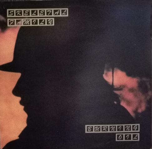 LP cover for Burning Oil by Skeletal Family. Cover has a red background with a silhouette of someone wearing a hat as the main feature of the cover.