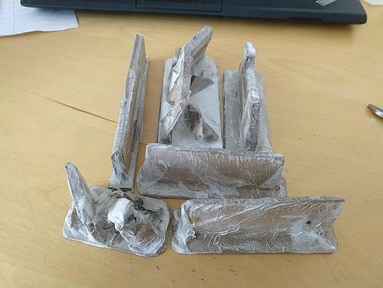 Six pieces of scatter terrain, representing ruined walls and rocky outcroppings, made of scrap cardboard glued to greyboard bases and covered in PVA and tissue paper.