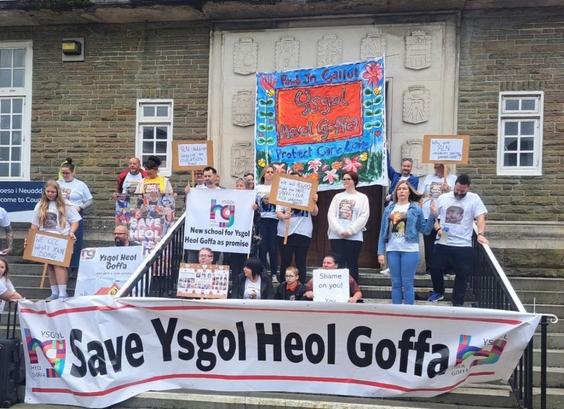 Parents and campaigners holding Save Ysgol Heol Goffa banners during a protest outside Carmarthenshire County Hall.