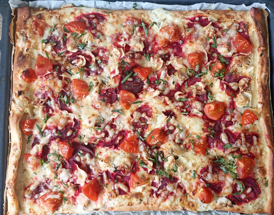 Die fertig gebackene Pizza auf dem Blech wie beschrieben + mit Estragon bestreut.
