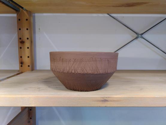 Bol en terre crue fraîchement tournassé Posé sur une étagère en bois