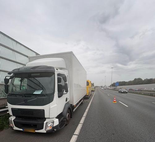 Een vrachtwagen staat met een kapotte band en velg op de A20 bij Rotterdam-Noord