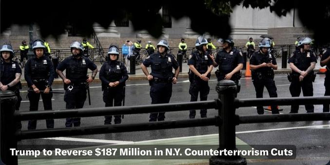 A line of NY police officers in riot gear stands on a street, facing forward. In the background, additional officers and bystanders are visible, with some bicycles parked nearby. The scene suggests a law enforcement presence during a public event or protest. Text overlay: Trump to Reverse $187M…