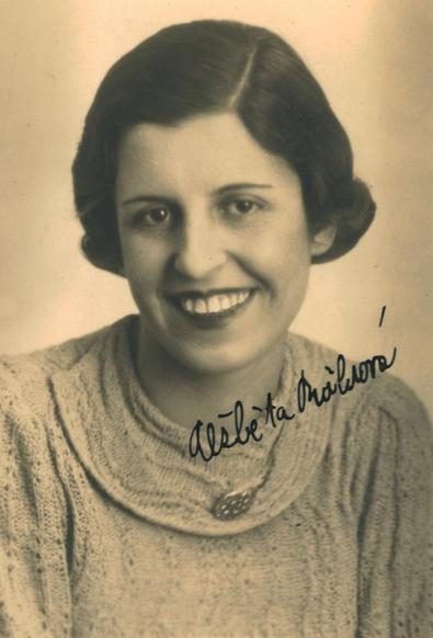Vintage black-and-white portrait of a smiling woman in a knitted sweater.