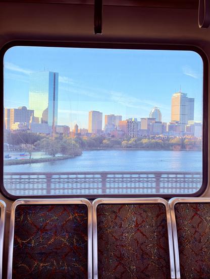 A photo out the window of a MBTA Red Line train showing the city of Boston, MA.