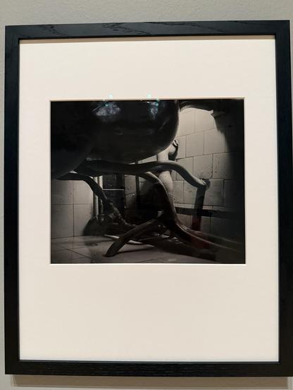 Photo of convoluted 1940s plumbing. The part half hidden in the background suggests a naked body almost.