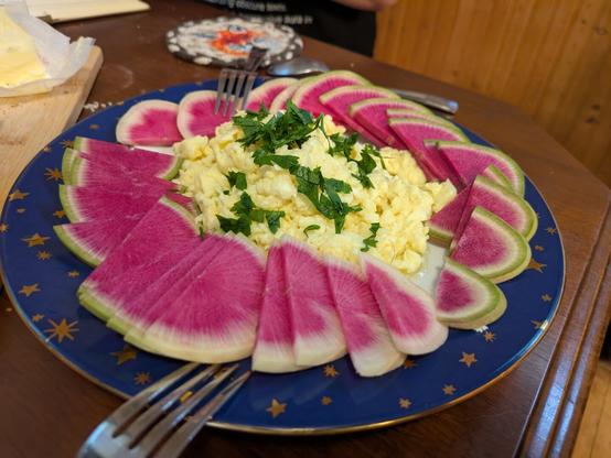 Scrambled eggs surrounded by slices of watermelon radishes