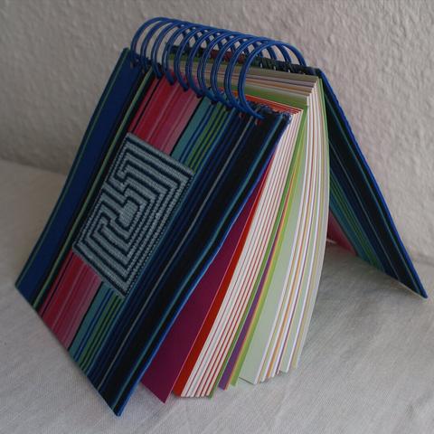 Drahtgebundenes Notizbuch mit gesticktem Labyrinth und verschiedenfarbigen Seiten