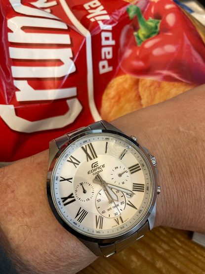 Casio Uhr am Handgelenk, dahinter eine Chipstüte.