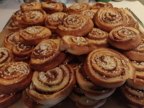 En stor hög med nybakade kanelbullar.
