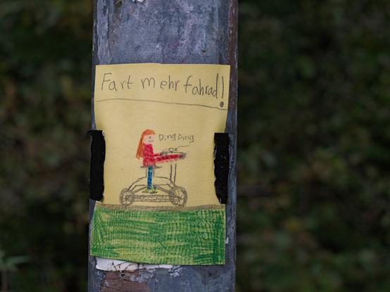 Colour photo of a hand drawn leaflet that says (in eaven worse spelling then mine): "ride your bisicle more often" "ring ,ring"