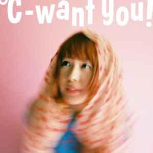 [pochette d'album :] °C-want you! en buste, de face, le regard tourné vers sa droite, un foulard rose à pois rouges sur la tête, sur un fond rose uni. Le cliché est globalement flou, sans doute parce que saisi dans le mouvement, mais le visage est net. Au-dessus d'elle, sur le fond rose, en grands caractères blancs, son nom d'artiste.