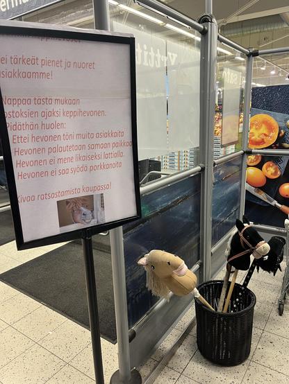 Ein Supermarkteingang in #Helsinki. In einem Kübel warten Steckenpferde auf einen Ausritt.