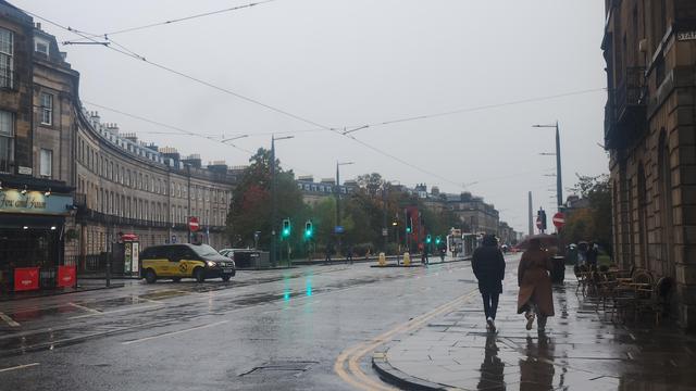 Looking along Shandwick Place in Edinburgh's West End on a rainy, grey day, the only bright colours from traffic lights, reflecting in the wet road surface