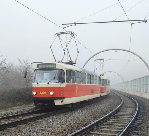 A tram traveling along a curved track in a fog.