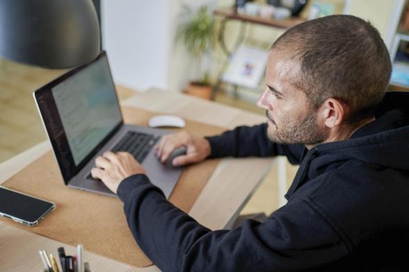 Un hombre frente a un ordenador en su mesa de oficina (Getty Images)