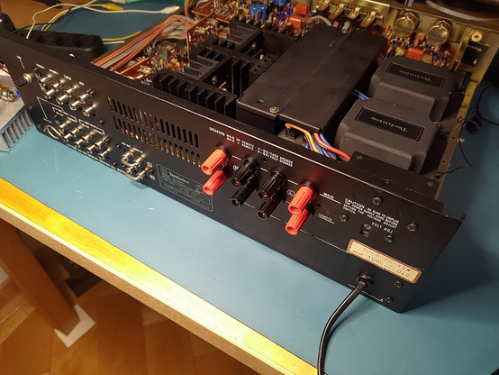 The rear of a Technics SU-8080 hifi amplifier. The focus is on the speaker terminals which have been replaced by more traditional binding posts.
