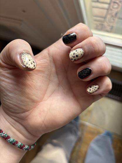 My left hand wearing Holo Taco nail polish in two colours, alternating between each finger:

One-Coat Black with Scattered Holo Taco
Butter Me Up with Milky White Shimmer

On the ivory fingers (Butter Me Up), I applied stamps made in One-Coat Black, shaped like a scatter of tiny stars.