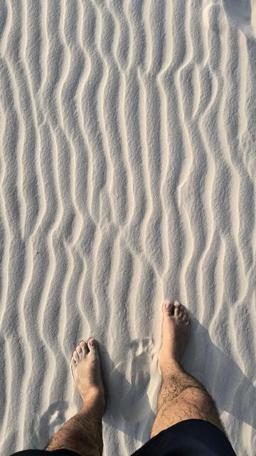 Foto das areias dos lençóis maranhenses e meus pés na parte inferior numa vista de cima.