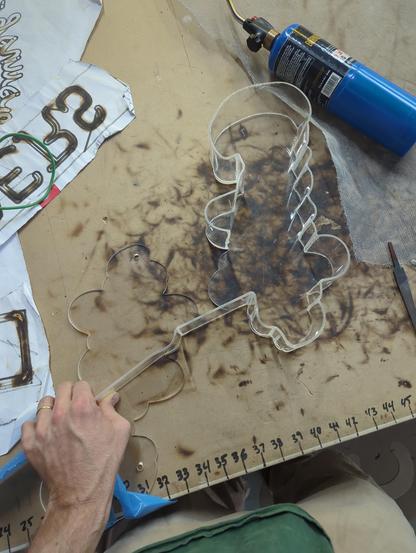 bending the acrylic channel letter. Its kinda like bending neon with the measurements, but a little more sticking it down as you go. The acrylic stays hot FOREVER compared to glass