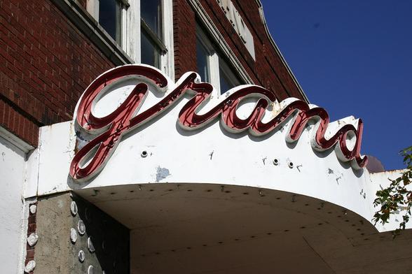 One corner of the Grand Theater marquee, showing the neon "Grand" sign in red script.