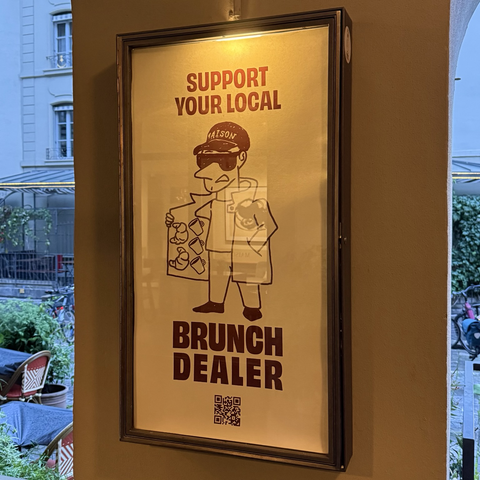 Schild an einem Pfeiler in der Berner Hotelgasse: „Support your local Brunch Dealer“.