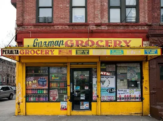 Guzman Grocery - a small grocery shop, or bodega, on a the corner of a city blog.