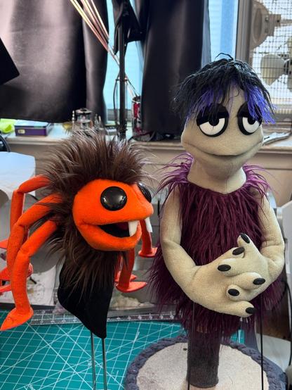 A spider hand puppet and a pointy head goth