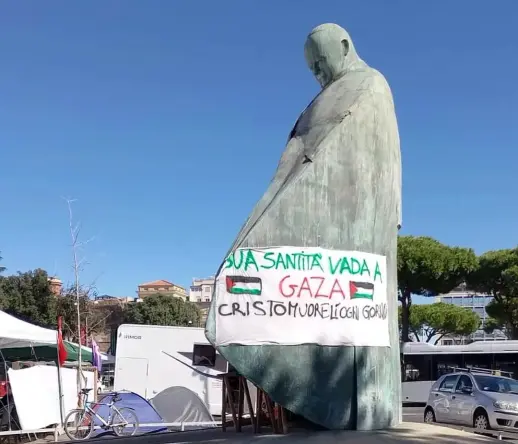 "your Holiness, go to Gaza - Jesus Christ dies there everyday" poster  on Giovanni Paolo II statue  at Piazza dei Cinquecento, Rome
