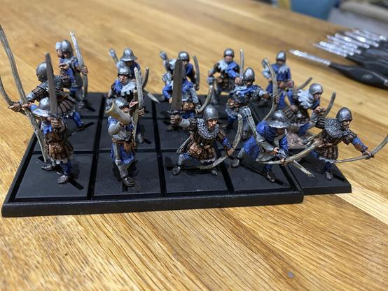 Regiment of Bretonnian Metal Archers. They are painted in Blue and White. There’s a set of freshly cleaned brushes in the background.