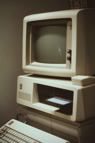 old computer with keyboard near wall