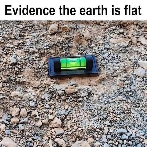 Photo of a bubble level tool placed on rocky ground, with caption: “Evidence the earth is flat.” The joke mocks flat earth conspiracy theories by pretending the bubble level proves the planet isn’t round.