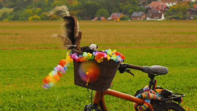 Fahrrad mit Lenkerkorb . Ein buntes Windrad dreht sich schnell im Wind