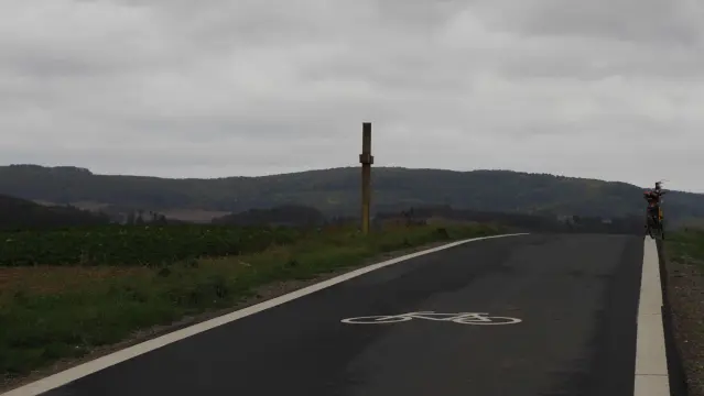 Fahrradstraße , links ein Wegkreuz , rechts ein Fahrrad