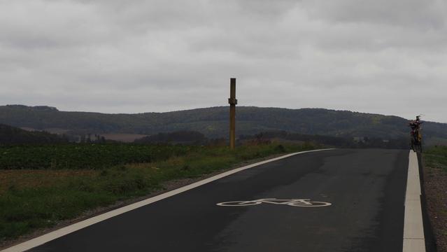 Fahrradstraße , links ein Wegkreuz , rechts ein Fahrrad