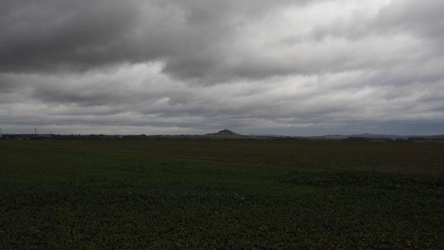 Tiefhängende Wolken über der Warburger Börde, in der Ferne ist der Vulkankegel des Desenberges zu sehen